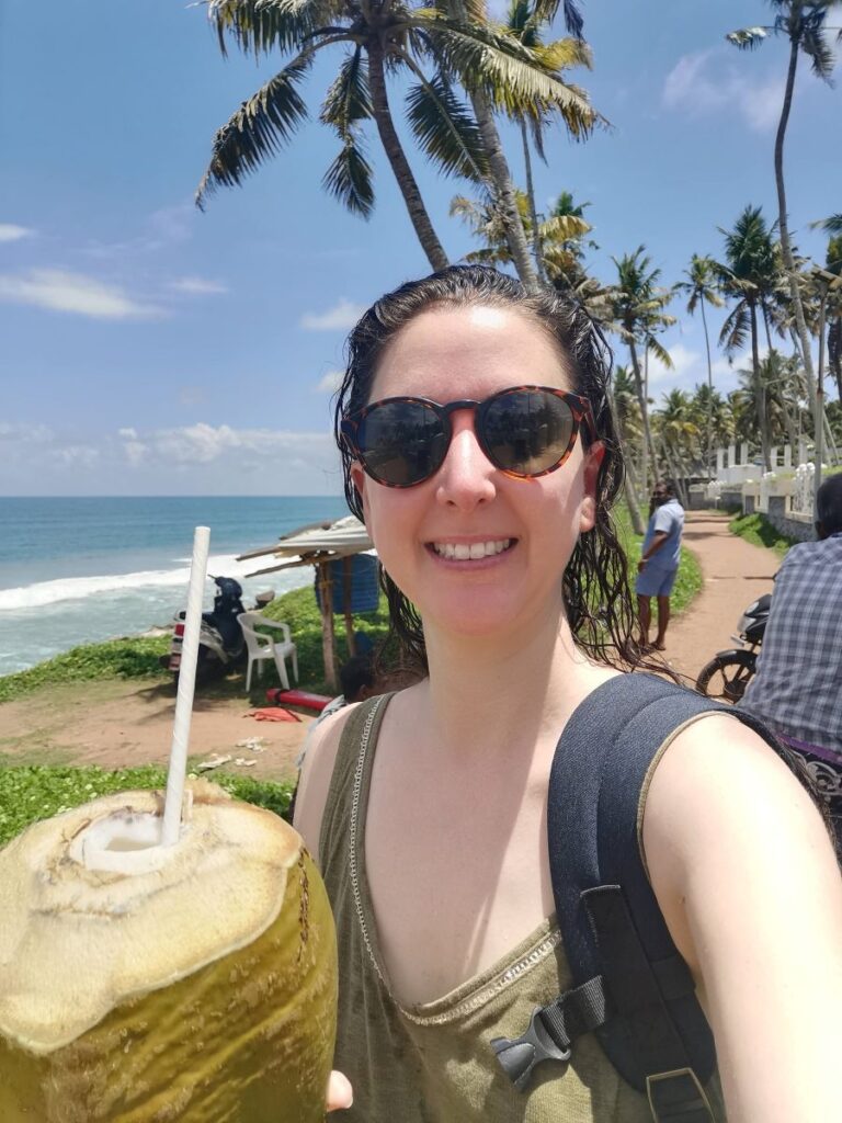 Aurélie à la plage de Varkala au Kerala en Inde avec un coconut