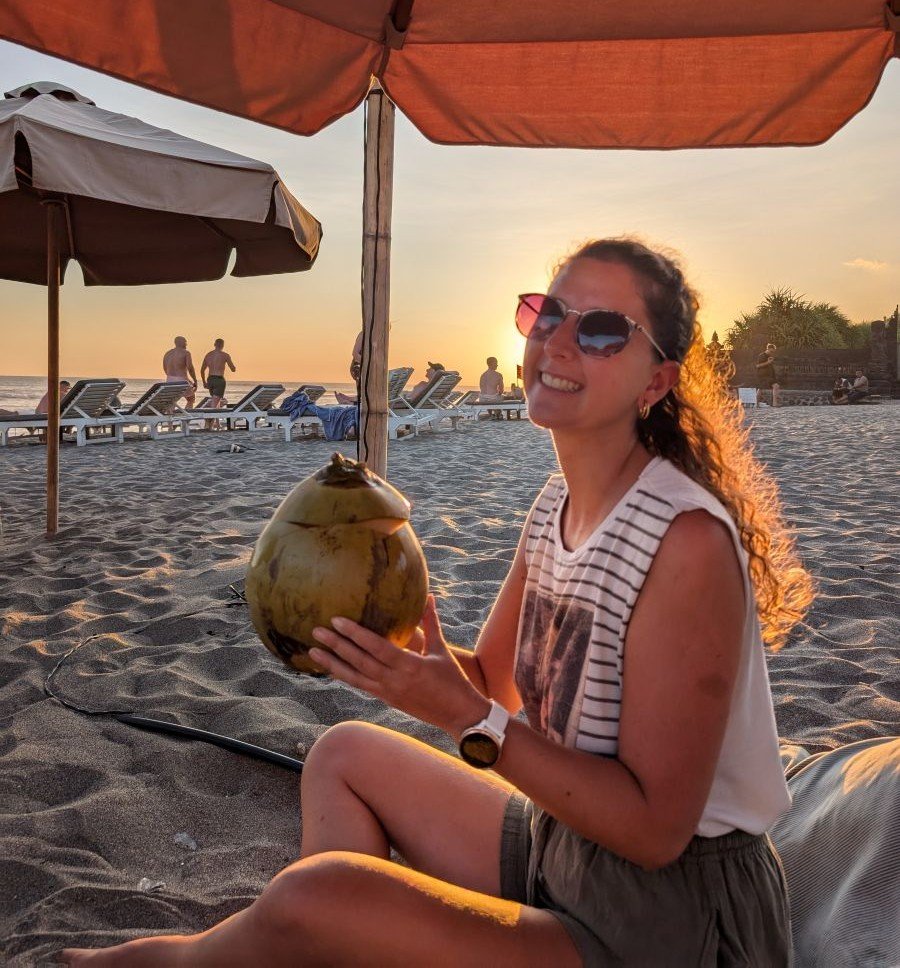 Aurélie expatriée à Bali avec un coconut sur la plage, auteure du guide carte SIM Bali