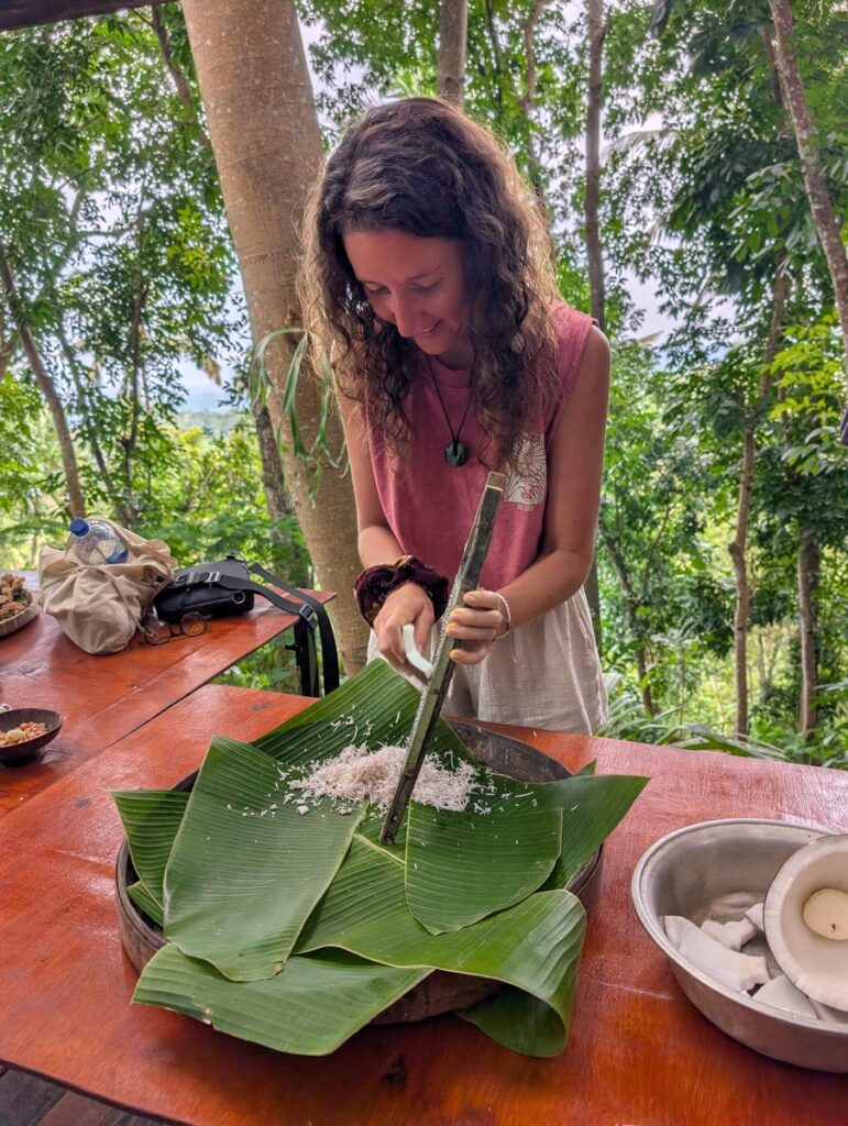 Aurélie de Lili Foodies Travel râpant une noix de coco fraîche lors du cours de cuisine Mystery Mountain Sidemen Bali