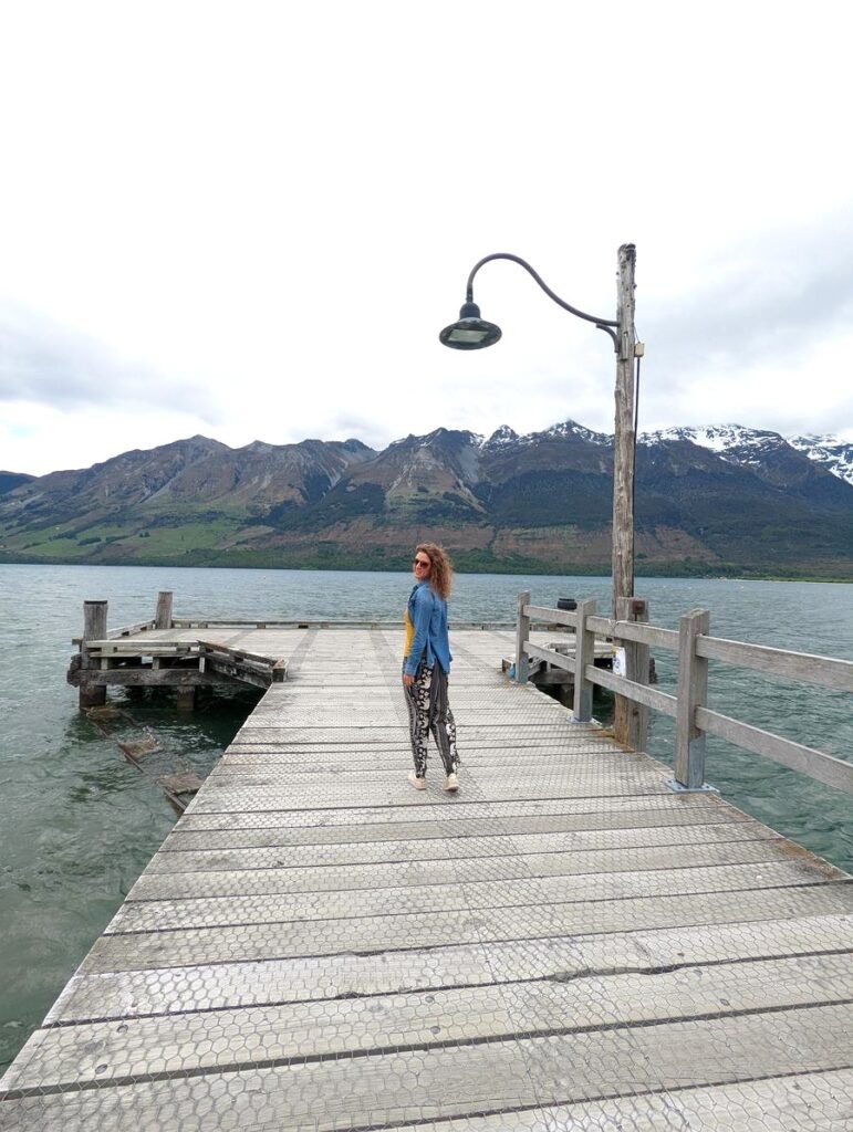 Aurélie de Lili Foodies Travel sur le wharf de Glenorchy avec les montagnes enneigées en arrière-plan, Nouvelle-Zélande