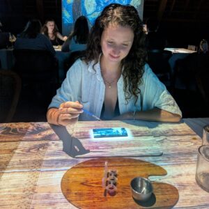 Aurélie de Lili Foodies Travel en train de peindre au restaurant gastronomique immersif Seven Paintings Ubud Bali