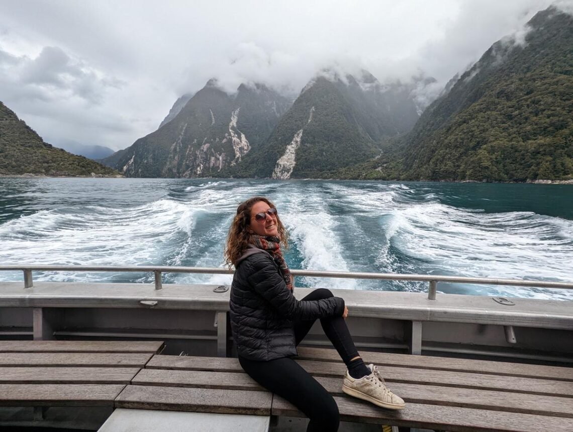 Aurélie de Lili Foodies Travel assise à l'arrière du bateau Mitre Peak sur le fjord de Milford Sound en Nouvelle-Zélande