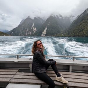 Aurélie de Lili Foodies Travel assise à l'arrière du bateau Mitre Peak sur le fjord de Milford Sound en Nouvelle-Zélande