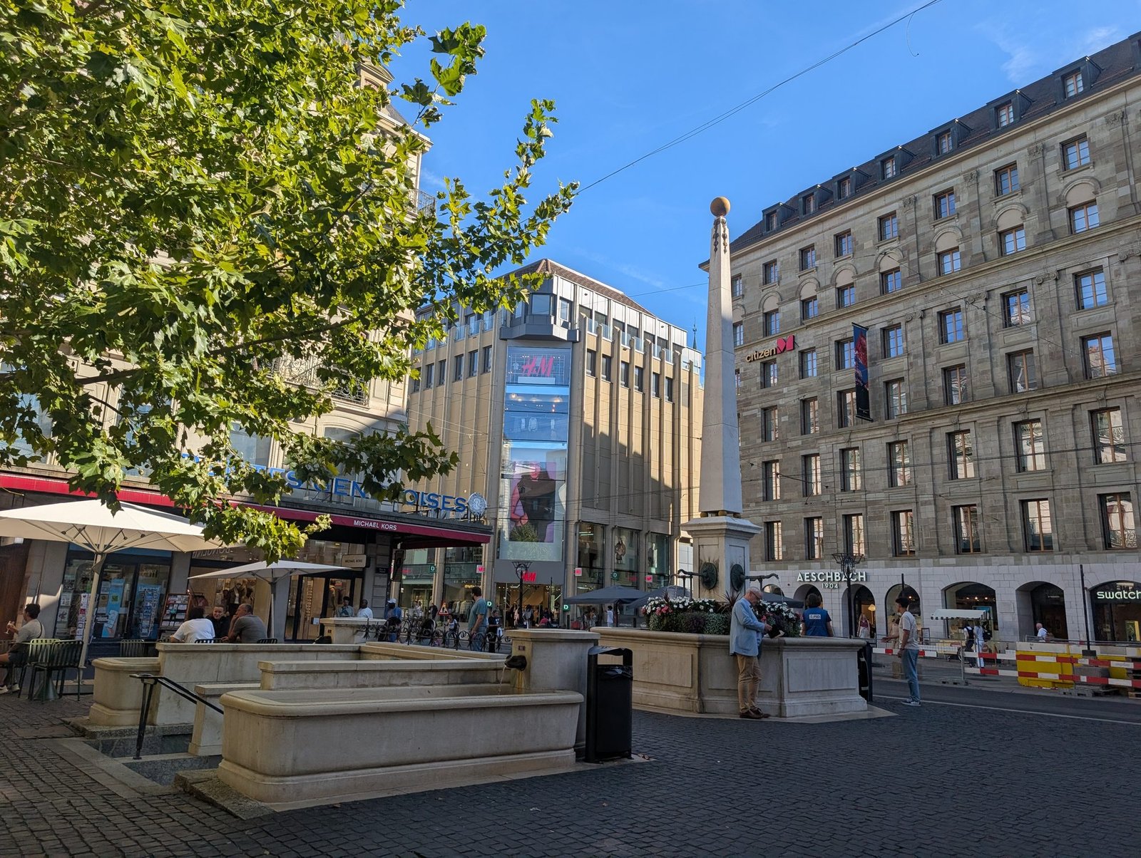 Place du Molard à Genève avec fontaines historiques et boutiques